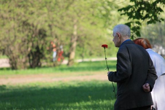 Ein älteres Paar geht auf einem Rasenfriedhof